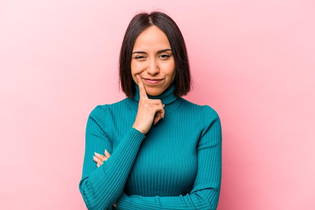 Young hispanic woman isolated on pink background contemplating\
planning a strategy thinking about the way of a business