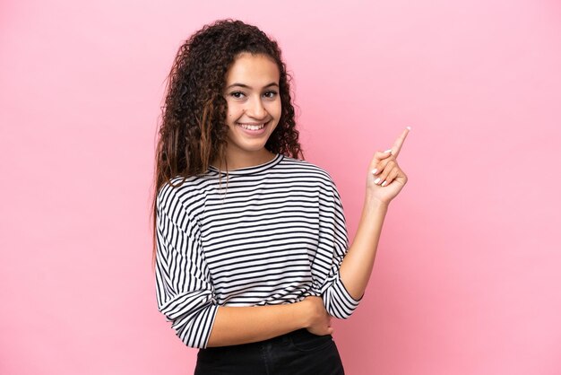 Photo young hispanic woman isolated on pink background pointing finger to the side