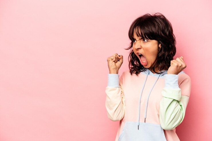 Photo young hispanic woman isolated on pink background raising fist after a victory winner concept
