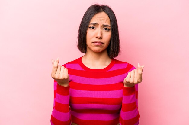 彼女はお金がないことを示すピンクの背景に分離された若いヒスパニック系の女性
