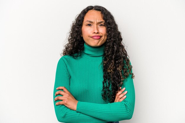 Young hispanic woman isolated on white background frowning face in displeasure keeps arms folded