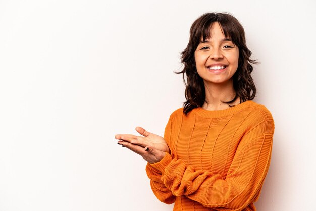 Photo young hispanic woman isolated on white background holding a copy space on a palm