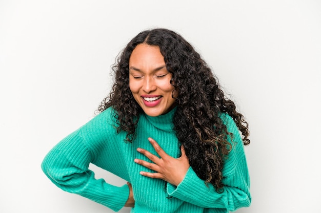 Young hispanic woman isolated on white background laughing keeping hands on heart concept of happiness