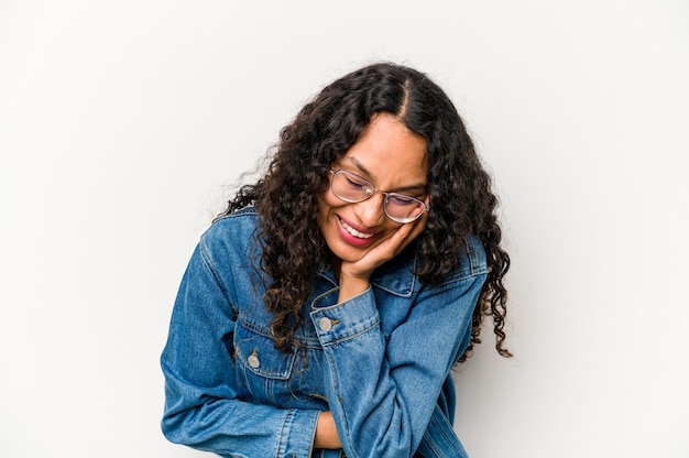 Young hispanic woman isolated on white background laughs happily and has fun keeping hands on stomach