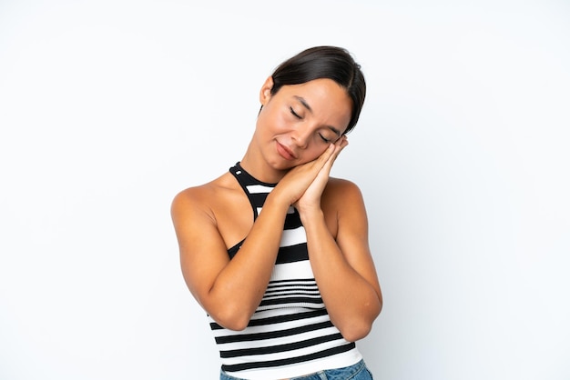 Young hispanic woman isolated on white background making sleep gesture in dorable expression