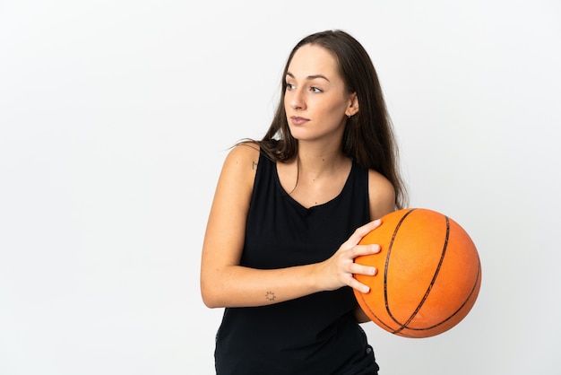 Young hispanic woman over isolated white background playing basketball