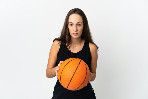 Молодая латиноамериканская женщина на изолированном белом фоне играет в баскетбол