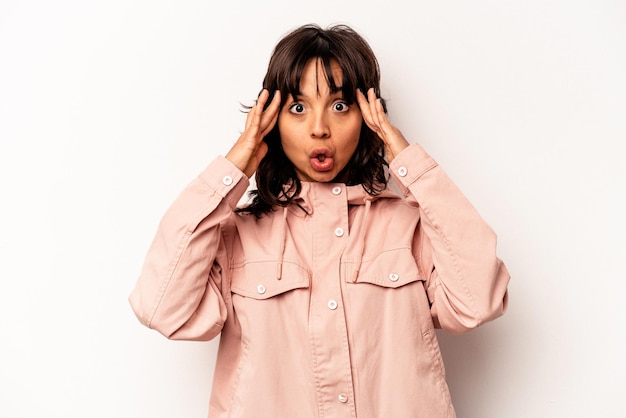 Young hispanic woman isolated on white background receiving a pleasant surprise excited and raising hands