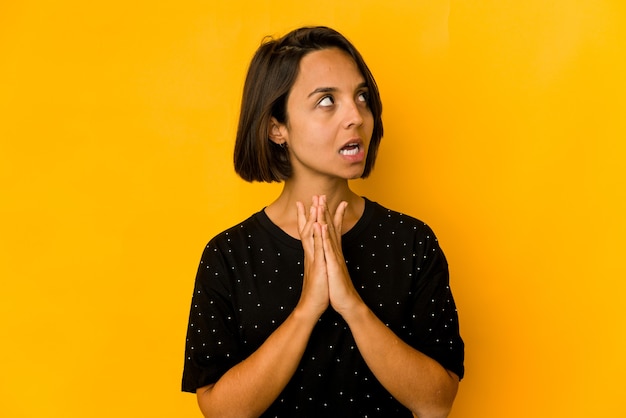 Young hispanic woman isolated on yellow making up plan in mind, setting up an idea.