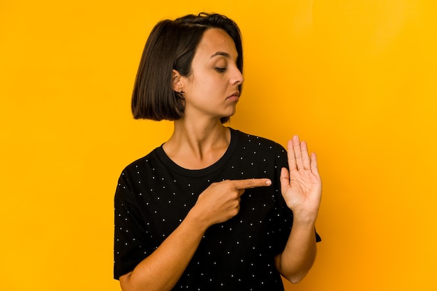 Photo young hispanic woman isolated on yellow smiling cheerful showing number five with fingers.