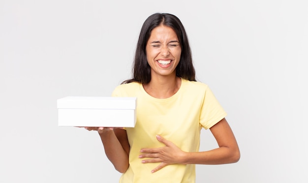 Young hispanic woman laughing out loud at some hilarious joke