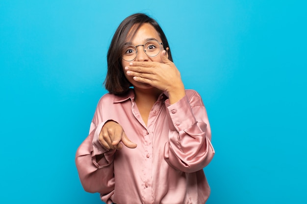 young hispanic woman laughing at you, pointing and making fun of or mocking you