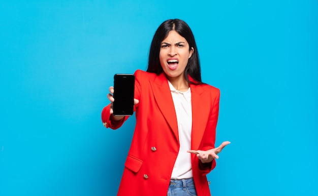 Young hispanic woman looking angry, annoyed and frustrated screaming