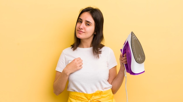 Young hispanic woman looking arrogant successful positive and proud clothes iron concept