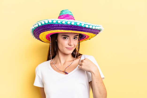 Young hispanic woman looking arrogant, successful, positive and proud. mexican hat concept