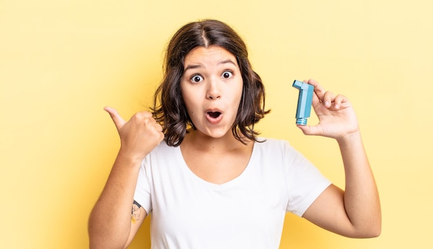 Young hispanic woman looking astonished in disbelief. asthma concept