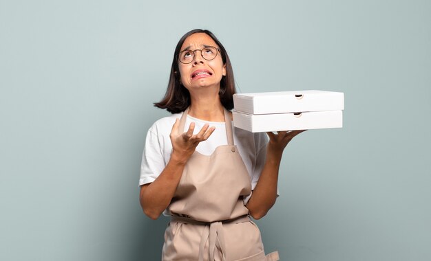 Young hispanic woman looking desperate and frustrated, stressed, unhappy and annoyed, shouting and screaming