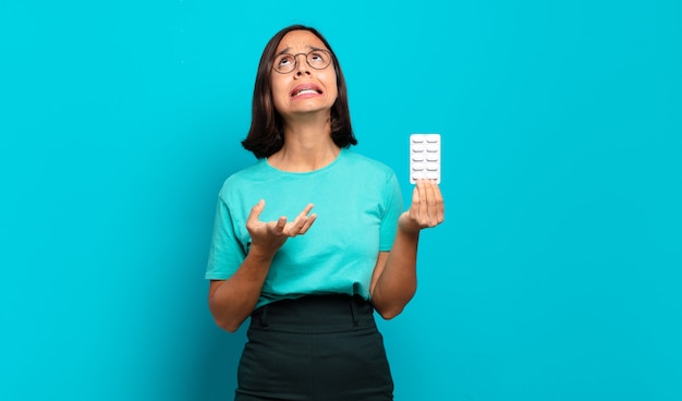 Young hispanic woman looking desperate and frustrated, stressed, unhappy and annoyed, shouting and screaming