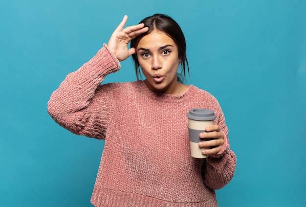 Photo young hispanic woman looking happy, astonished and surprised, smiling and realizing amazing and incredible good news