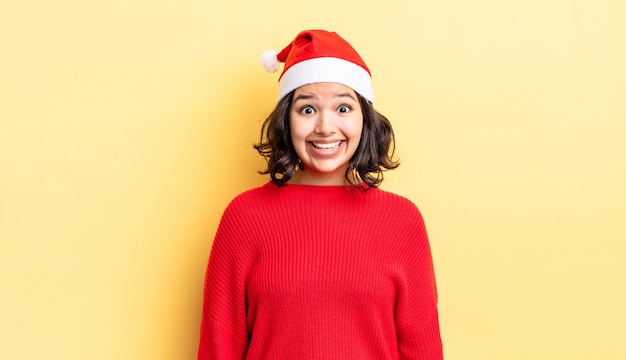 Young hispanic woman looking happy and pleasantly surprised. christmas concept