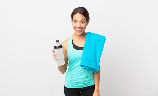 Young hispanic woman looking happy and pleasantly surprised. fitness concept