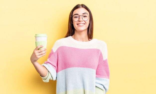 Young hispanic woman looking happy and pleasantly surprised. take away coffee concept