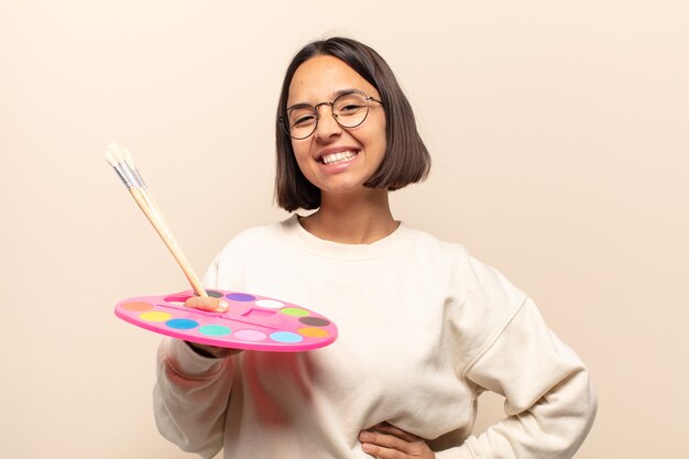 Young hispanic woman looking like a happy, proud and satisfied achiever smiling with arms crossed