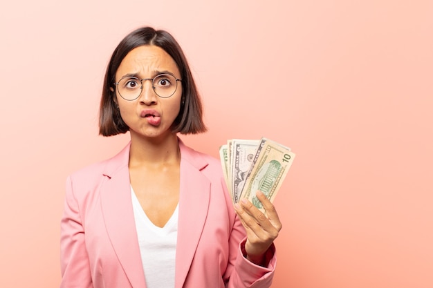 Young hispanic woman looking puzzled and confused, biting lip with a nervous gesture, not knowing the answer to the problem