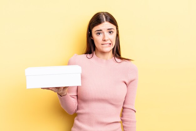 Young hispanic woman looking puzzled and confused. empty box concept