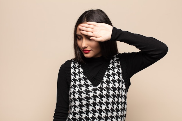 Young hispanic woman looking stressed, tired and frustrated, drying sweat off forehead, feeling hopeless and exhausted