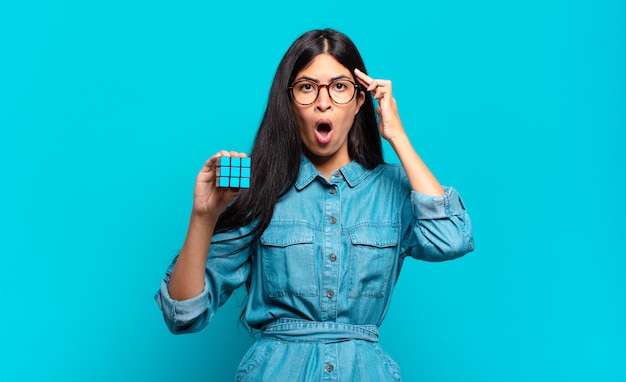 Young hispanic woman looking surprised, open-mouthed, shocked, realizing a new thought, idea or concept. intelligence problem concept