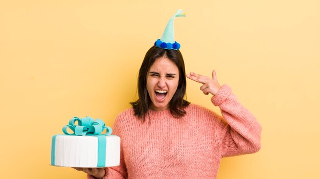 Young hispanic woman looking unhappy and stressed suicide gesture making gun sign birthday concept