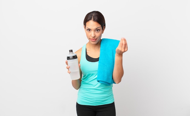 young hispanic woman making capice or money gesture, telling you to pay. fitness concept