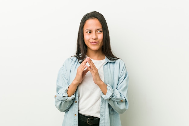 Young hispanic woman making up plan in mind, setting up an idea.