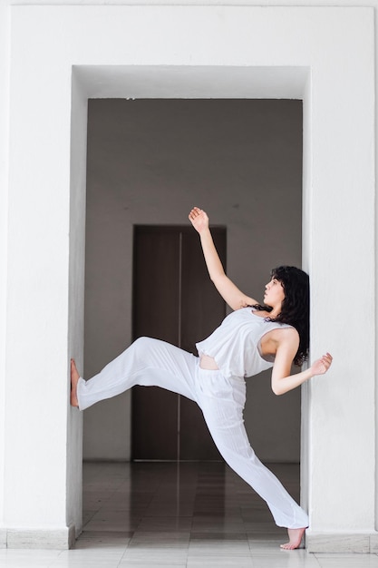 Young hispanic woman performing dance positions in a studio