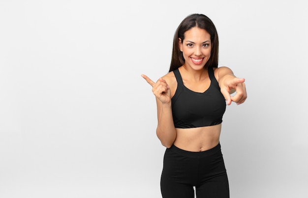 Young hispanic woman pointing at camera choosing you. fitness concept