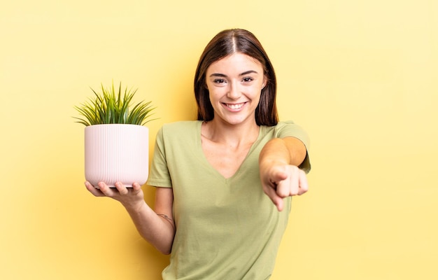 あなたを選んでカメラを指している若いヒスパニック系の女性。植木鉢のコンセプト