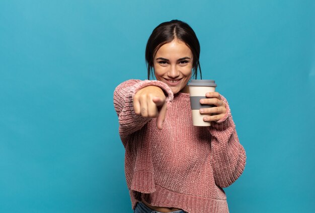 Young hispanic woman pointing at camera with a satisfied, confident, friendly smile, choosing you