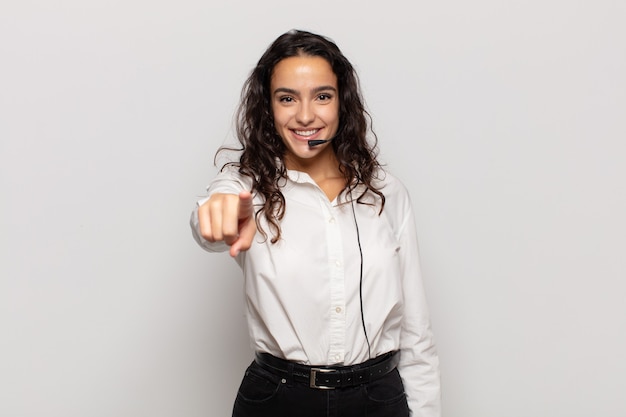 Young hispanic woman pointing at camera with a satisfied, confident, friendly smile, choosing you