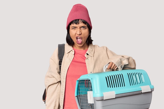 Young Hispanic woman ready for travel with pet carrier person pointing by hand