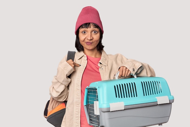 Young Hispanic woman ready for travel with pet carrier showing number two with fingers