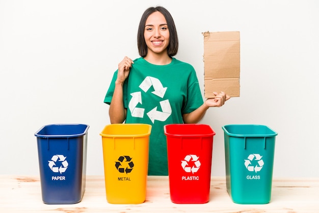 Young hispanic woman recycling cardboard isolated on white background