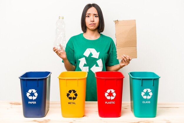 Young hispanic woman recycling cardboard isolated on white background