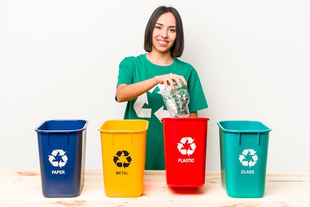 Young hispanic woman recycling plastic isolated on white background