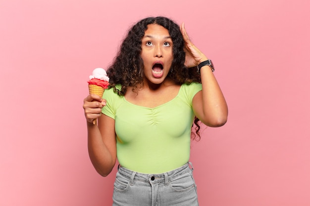 Young hispanic woman screaming with hands up in the air, feeling furious, frustrated, stressed and upset