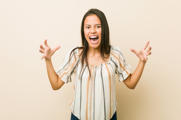 Young hispanic woman screaming with rage.