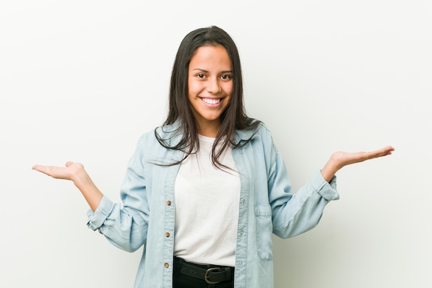 Young hispanic woman showing a welcome expression.