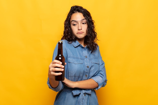 Young hispanic woman shrugging, feeling confused and uncertain, doubting with arms crossed and puzzled look