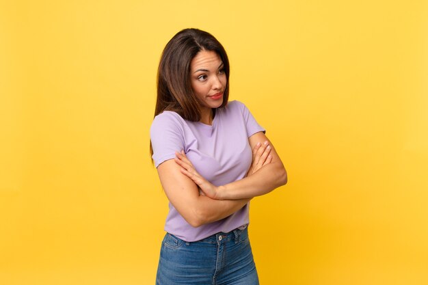 Young hispanic woman shrugging, feeling confused and uncertain