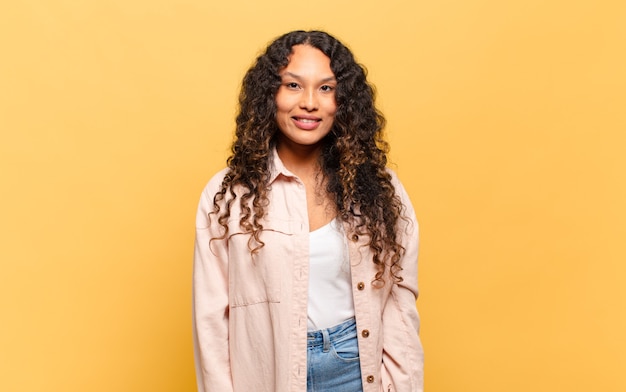 Young hispanic woman smiling cheerfully and casually with a positive, happy, confident and relaxed expression